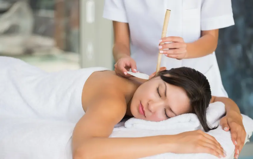 俯卧接受耳烛疗法的女性